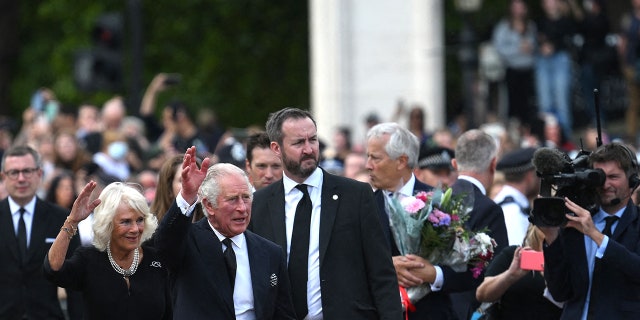 Britain's King Charles III and Camilla, queen consort, wave as they greet the crowd upon their arrival Buckingham Palace.