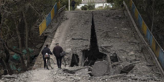 People inspect a bridge after the Ukrainian army liberated the town of Balakliya in the southeastern Kharkiv oblast, Ukraine, on Sept. 11, 2022. 