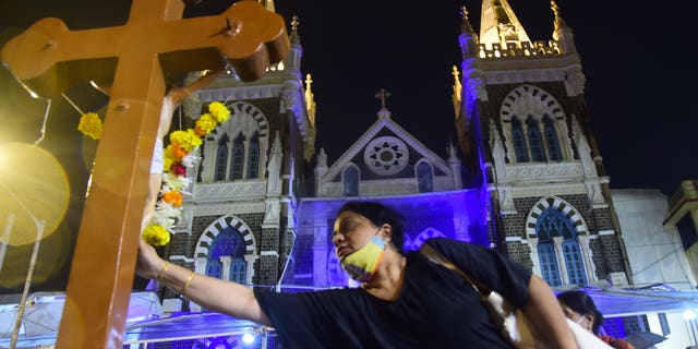 Christians touch the cross at Mount Mary Church on the eve of the Mount Mary Fair in Bandra, Mumbai, India, September 10, 2022.