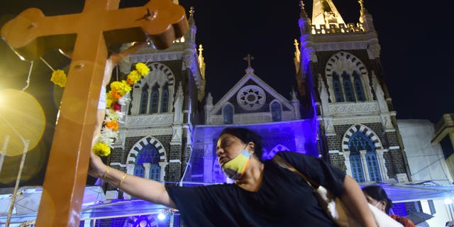 Christians touch the cross at Mount Mary Church on the eve of the Mount Mary Fair in Bandra, Mumbai, India, September 10, 2022.