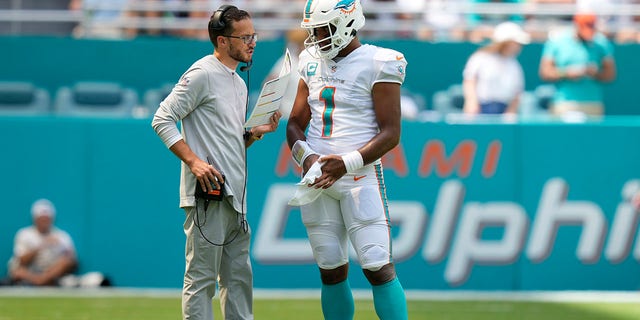 Miami Dolphins head coach Mike McDaniel speaks with Miami Dolphins quarterback Tua Tagovailoa (1) during a game interruption against the New England Patriots on September 11, 2022 at Hard Rock Stadium in Miami Gardens, Florida.
