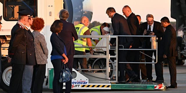 Pope Francis boards his plane from a lift designed for the boarding and off boarding of reduced mobility passengers, on Sept. 13, 2022, at Rome's Fiumicino airport, as he departs for a three-day trip to Kazakhstan. 