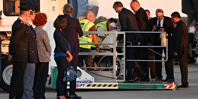 Pope Francis boards his plane from a lift designed for the boarding and off boarding of reduced mobility passengers, on Sept. 13, 2022, at Rome's Fiumicino airport, as he departs for a three-day trip to Kazakhstan. 