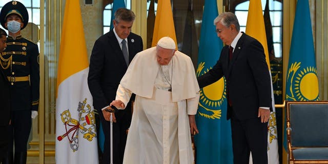 Pope Francis is greeted by Kazakh President Kassym-Jomart Tokayev upon his arrival at Nur-Sultan International Airport in Nur-Sultan on September 13, 2022. 