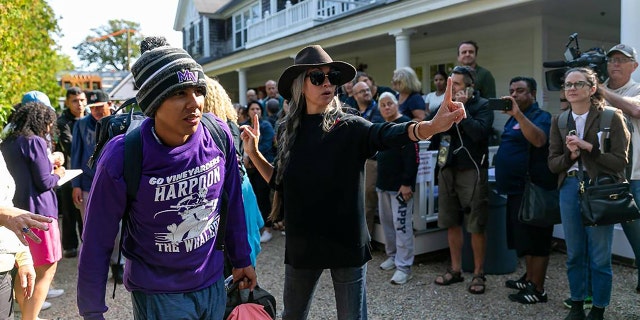 A Venezuelan migrant is led onto a bus at St. Andrew's Episcopal Church on Friday, Sept. 16, 2022, in Edgartown, Massachusetts, on the island of Martha's Vineyard.