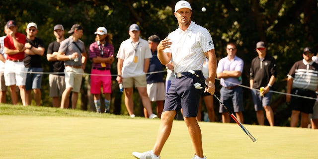 Golfer Liv Westwood watches Bryson DeChambeau throw his ball into the can on 12th green during the first round of the LIV Golf Invitational Series Chicago on September 16, 2022, at Rich Harvest Farms in Sugar Grove, Illinois.