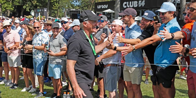 LIV CEO and commissioner Greg Norman high fives the fans as he walks to the first tee during the final round of the LIV Golf Invitational Series Chicago at Rich Harvest Farms in Sugar Grove, Illinois.