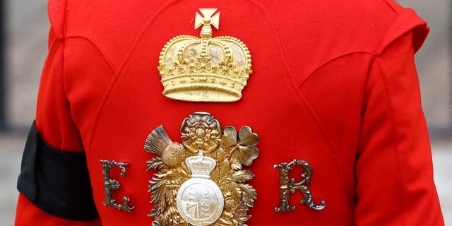 The cypher of Queen Elizabeth II is pictured on the uniform of a royal guard standing at Westminster Abbey in London on Sept. 19, 2022.