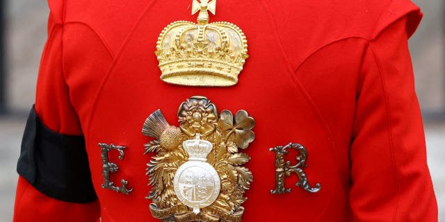 The cypher of Queen Elizabeth II is pictured on the uniform of a royal guard standing at Westminster Abbey in London on Sept. 19, 2022.