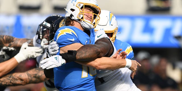 Los Angeles Chargers quarterback Justin Herbert, #10, is hit after throwing a pass during the NFL regular season game between the Jacksonville Jaguars and the Los Angeles Chargers on Sept. 25, 2022, at SoFi Stadium in Inglewood, California. 
