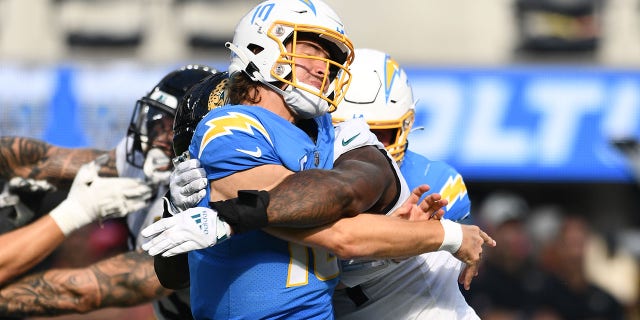 Los Angeles Chargers quarterback Justin Herbert, #10, is hit after throwing a pass during the NFL regular season game between the Jacksonville Jaguars and the Los Angeles Chargers on Sept. 25, 2022, at SoFi Stadium in Inglewood, California.