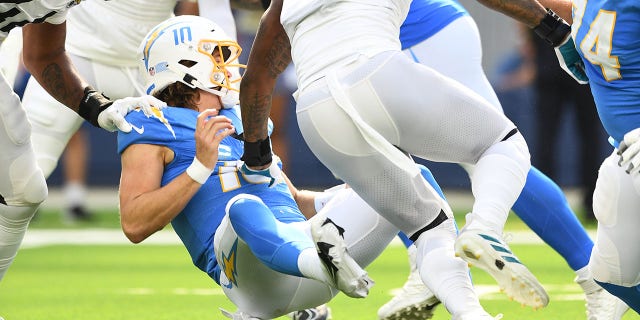 Los Angeles Chargers quarterback Justin Herbert, #10, is hit after throwing a pass during the NFL regular season game between the Jacksonville Jaguars and the Los Angeles Chargers on Sept. 25, 2022, at SoFi Stadium in Inglewood, California.