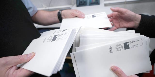 The first letters are franked with the new cypher of King Charles III in the Court Post Office at Buckingham Palace on Sept. 27, 2022 in London.