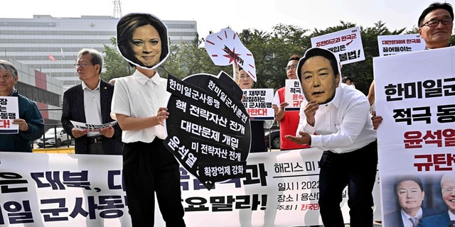 Des militants portent des masques montrant les visages du vice-président Kamala Harris et du président sud-coréen Yoon Suk-yeol lors d'une manifestation contre la visite de Harris et l'alliance Corée du Sud-États-Unis, près du bureau présidentiel à Séoul le 29 septembre 2022.