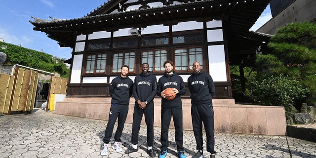 Stephen Curry #30, Draymond Green #23, Klay Thompson #11 and Andre Iguodala #9 of the Golden State Warriors poses for a group photo by the Tokyo Tower on September 29, 2022, in Tokyo, Japan.