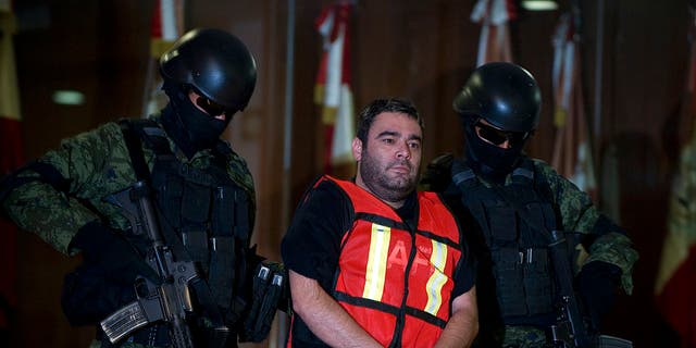Mexican soldiers escort Juan Francisco Sillas-Rocha, aka "El Sillas" or "El Rueda," allegedly one of the main collaborators of the leader of the drug cartel "Arellano Felix," during his presentation to the press in Mexico City, on Nov. 7, 2011. Sillas-Rocha has been transferred to North Dakota to face criminal charges.