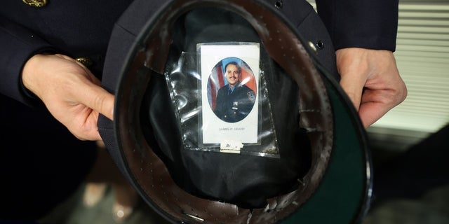 NYPD Officer Joseph Safatle shows the photograph of his uncle, Officer James Leahy, that he carries inside his hat during the unveiling of the 9/11 Memorial Wall at the Police Benevolent Association of the City of New York on September 07, 2021 in New York City. 
