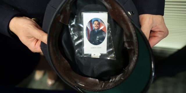 NYPD Officer Joseph Safatle shows the photograph of his uncle, Officer James Leahy, that he carries inside his hat during the unveiling of the 9/11 Memorial Wall at the Police Benevolent Association of the City of New York on September 07, 2021 in New York City. 