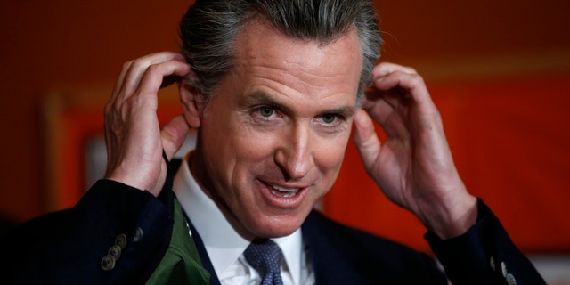 Removed by Democratic California Gov.  Gavin Newsom his mask before a press conference.