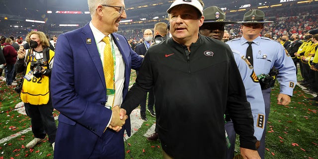 Head Coach Kirby Smart of the Georgia Bulldogs shakes hands with SEC Commissioner Greg Sankey after the Georgia Bulldogs defeated the Alabama Crimson Tide 33-18 in the 2022 CFP National Championship Game at Lucas Oil Stadium on January 10, 2022 in Indianapolis, Indiana. 