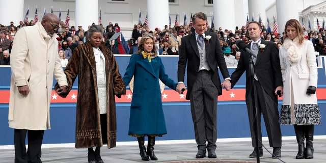 Terrence Sears, Virginia Lieutenant Governor Winsome Sears, Suzanne Youngkin, the first lady of Virginia, Virginia Governor Glenn Youngkin, Virginia Attorney General Jason Miyares, and his wife Page Miyares hold hands as the governor leads the group in prayer at the State Capitol on January 15, 2022 in Richmond.