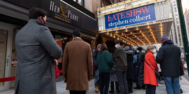 People stand in line outside "The Late Show with Stephen Colbert" at the Ed Sullivan Theater in Times Square on January 25, 2022 in New York City. 