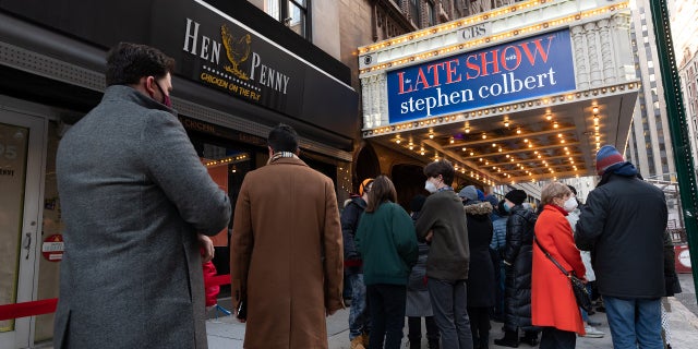 People stand in line outside "The Late Show with Stephen Colbert" at the Ed Sullivan Theater in Times Square on January 25, 2022 in New York City. 