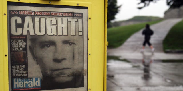 The early morning scene at Southie's Castle Island shows a newspaper June 23, 2011, announcing the capture of James "Whitey" Bulger. 