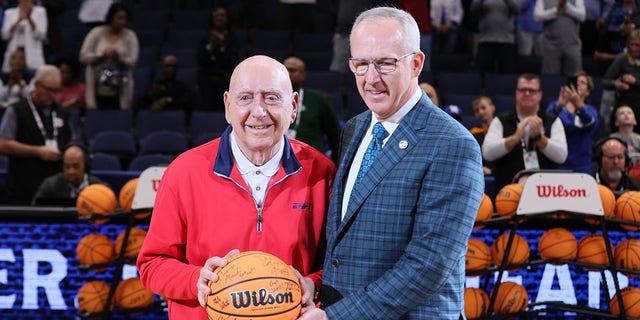 (L-R) College Basketball broadcaster Dick Vitale receives an autographed basketball from SEC Commissioner Greg Sankey prior to the start of the game between the Texas A&amp;M Aggies and Arkansas Razorbacks in the Semifinal game of the SEC Men's Basketball Tournament at Amalie Arena on March 12, 2022 in Tampa, Florida. 
