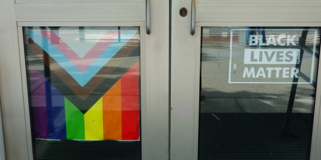 A LGBTQ flag and a Black Lives Matter banner hang on gym doors in Manhattan, New York.