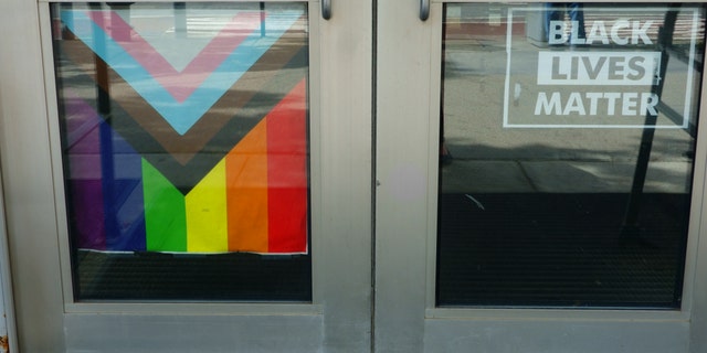 A LGBTQ flag and a Black Lives Matter banner hang on gym doors in Manhattan, New York.