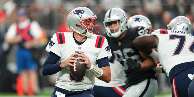 Quarterback Brian Hoyer of the New England Patriots looks to throw a pass against the Raiders at Allegiant Stadium on Aug. 26, 2022, in Las Vegas.