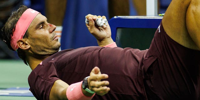 Rafael Nadal of Spain lies down to receive medical treatment after hitting himself with his own racquet during his match against Fabio Fognini of Italy in the second round of men's singles at the US Open at the USTA Billie Jean King National Tennis Center on September 01, 2022 in New York City.