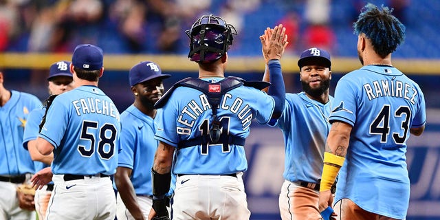 Manuel Margot (13) of the Tampa Bay Rays high-fives teammate Christian Bethancourt (14) after defeating the New York Yankees 9-0 at Tropicana Field Sept. 2, 2022, in St Petersburg, Fla. 