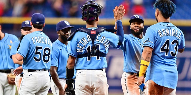 Manuel Margot (13) of the Tampa Bay Rays high-fives teammate Christian Bethancourt (14) after defeating the New York Yankees 9-0 at Tropicana Field Sept. 2, 2022, in St Petersburg, Fla. 