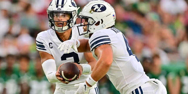 Jaren Hall (3) hands the ball off to Lopini Katoa (4) of the Brigham Young Cougars in the first quarter against the South Florida Bulls at Raymond James Stadium Sept. 3, 2022, in Tampa, Fla. 