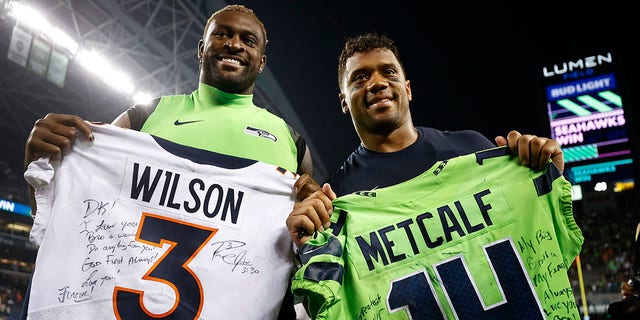 DK Metcalf of the Seahawks and Russell Wilson of the Denver Broncos exchange jerseys on Sept. 12, 2022, in Seattle, Washington.