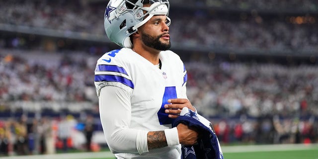 Dak Prescott of the Dallas Cowboys uses a towel to wipe his hand against the Tampa Bay Buccaneers at AT and T Stadium on Sept. 11, 2022, in Arlington, Texas.