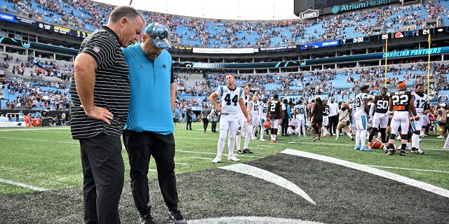Head coach Matt Rhule (in blue shirt) of the Carolina Panthers pauses for a brief prayer after a loss to the Cleveland Browns at Bank of America Stadium in Charlotte, North Carolina, on Sept. 11, 2022.
