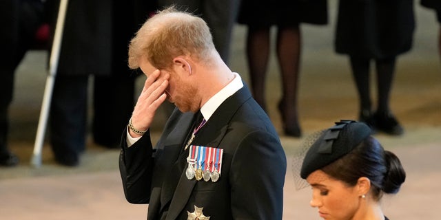 Um emocionado príncipe Harry e Meghan prestam suas homenagens no Palácio de Westminster após a procissão para a rainha Elizabeth II em 14 de setembro de 2022.