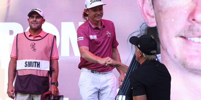 Greg Norman, CEO and Commissioner of LIV Golf, presents the trophy to Team Captain Cameron Smith of Punch GC after winning the individual title of the LIV Golf Invitational - Chicago at Rich Harvest Farms on September 18, 2022 in Sugar Grove, Illinois .