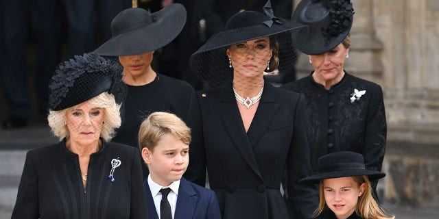 (LR) Camilla, Rainha Elizabeth, Meghan, Duquesa de Sussex, Príncipe George de Gales, Catherine, Princesa de Gales, Princesa Charlotte de Gales e Sophie, Condessa de Wessex durante o funeral de Estado da Rainha Elizabeth II na Abadia de Westminster em 19 de setembro, 2022 em Londres. 