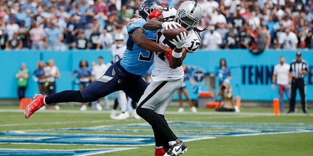 Wide receiver Davante Adams of the Las Vegas Raiders catches a touchdown in front of safety Kevin Byard of the Tennessee Titans at Nissan Stadium in Nashville on Sept. 25, 2022.