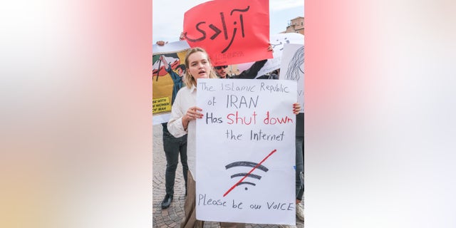 Iranian girl protests with sign in hand in front of Venice train station on Sept. 27, 2022, in Venice, Italy.