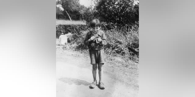 A French boy eating chocolate, which he was given by some American soldiers in 1944.
