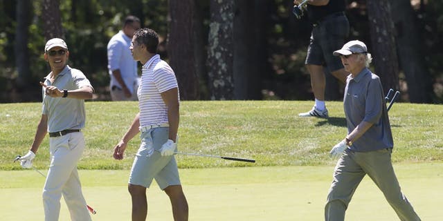President Barack Obama walks alongside Cyrus Walker and comedian Larry David as they play golf at Farm Neck Golf Club in Oak Bluffs on Martha's Vineyard.