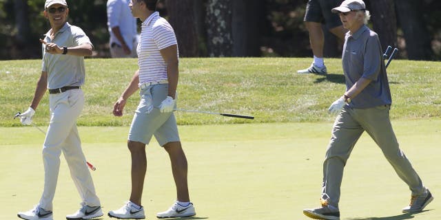 President Barack Obama walks alongside Cyrus Walker and comedian Larry David as they play golf at Farm Neck Golf Club in Oak Bluffs on Martha's Vineyard.