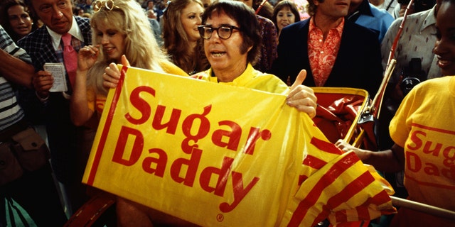 Tennis player Bobby Riggs holds a