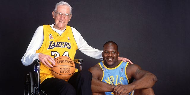 George Mikan de los Minneapolis Lakers, a la izquierda, posa con Shaquille O'Neal de Los Angeles Lakers durante una sesión de fotos en 2002. 