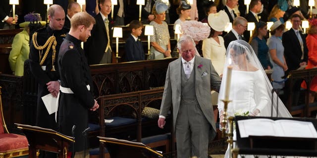 Instead of being led down the aisle with her own father, Meghan Markle was accompanied by Prince Harry's father, the new reigning monarch, King Charles III.
